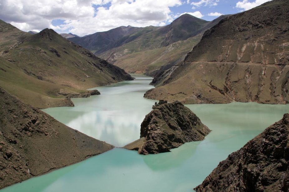 The shimmering turquoise waters of Yamdrok Yumtso lake is one of the sights that greet riders as they climb to lung-bursting heights in the shadow of Everest. The road stretches between Lhasa and the Nepalese border.