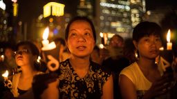 People take part in a candlelight vigil on the 25th anniversary of the Tiananmen Square protests during heavy rain on June 4, 2014 in Hong Kong.