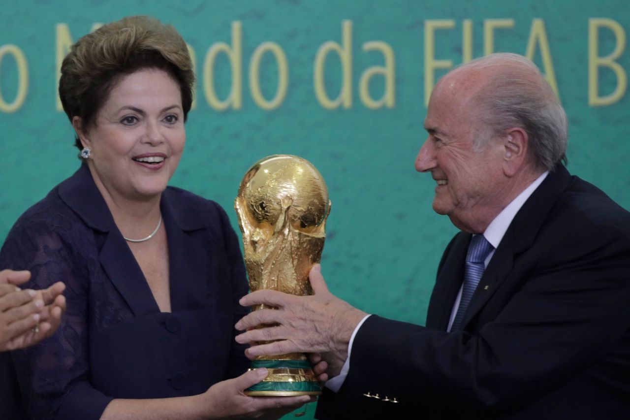 FIFA President Sepp Blatter, right, presents the 2014 World Cup trophy to Brazil's President Dilma Rousseff, during a ceremony at the Planalto presidential palace, in Brasilia, Brazil on June 2, 2014. 