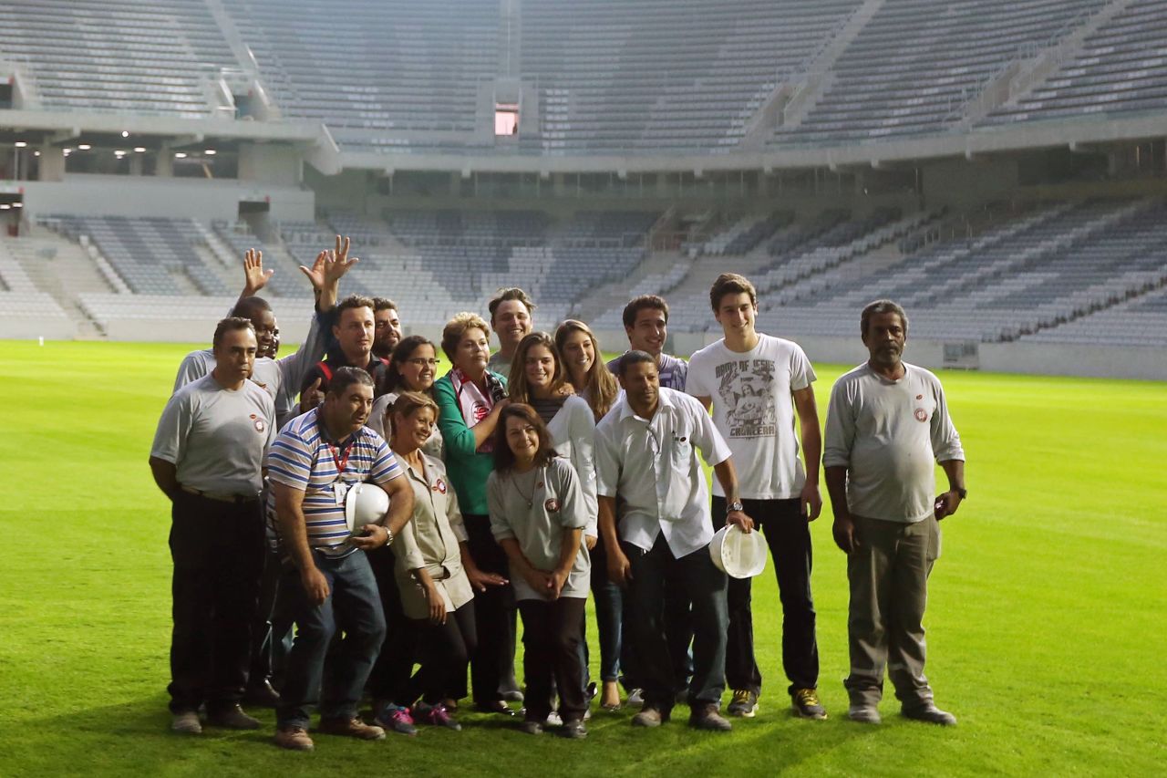 President Rousseff poses with workers as she visits Arena da Baixada stadium on May 9, 2014, which will host four matches of the upcoming FIFA World Cup Brazil 2014, in Curitiba, Brazil. 