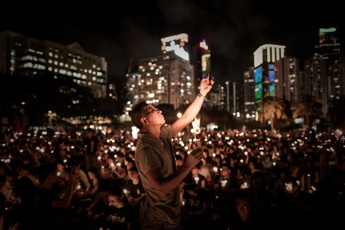 On the same night, a man takes a picture with his mobile phone in Hong Kong's Victoria Park, as thousands of people hold candles to commemorate the tragic events of 1989 -- the only Chinese territory permitted to mark the occasion.