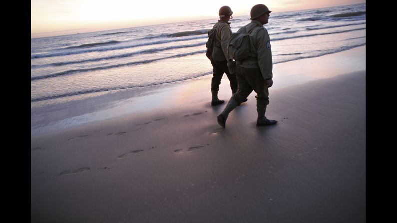 World War II reenactors walk along Omaha Beach near Vierville-sur-Mer, France, on Friday, June 6, the 70th anniversary of D-Day.