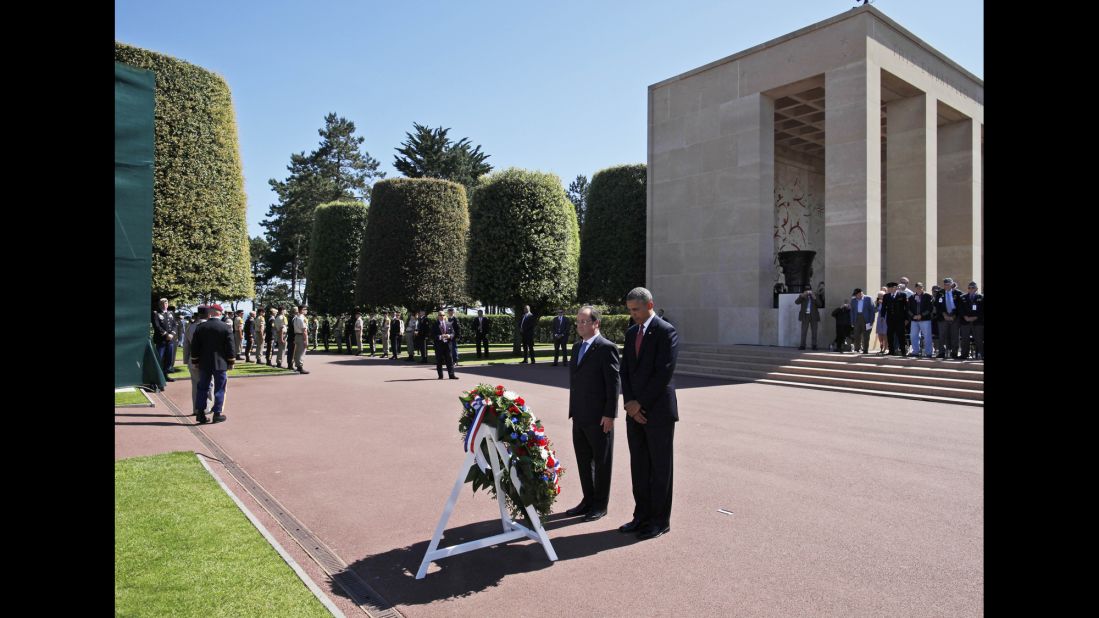 President Barack Obama and French President Francois Hollande pause for a moment of silence after laying a wreath at the Normandy American Cemetery in Colleville-sur-Mer, France, on Friday, June 6, the 70th anniversary of D-Day. Obama's travel agenda also includes Poland and Belgium.