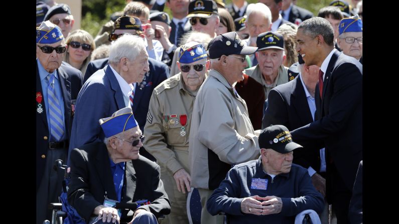 President Obama greets veterans during the D-Day ceremony in Colleville-sur-Mer.