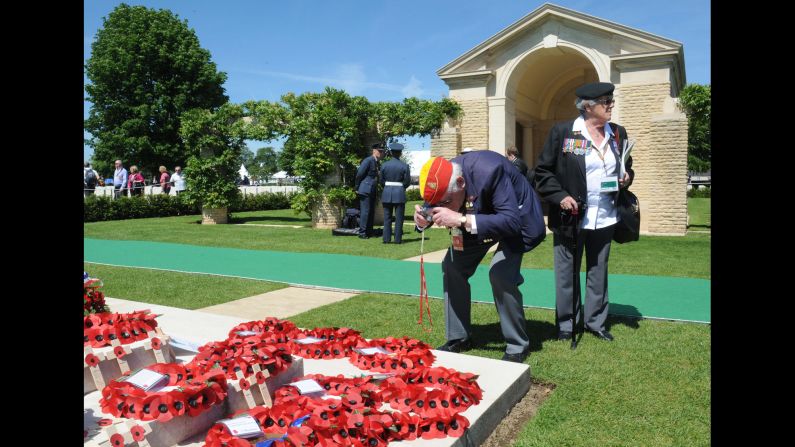 A British World War II veteran takes a picture of wreaths at the British War Cemetery in Bayeux, France.