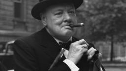 Caption:5th June 1941: Winston Churchill (1874 - 1965) pins his flag into his lapel after he had bought one in aid of Red Cross Day in London. (Photo by Central Press/Getty Images)