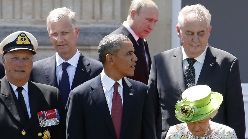 Caption:Russian President Vladimir Putin (C top) passes behind US President Barack Obama (C), Britain's Queen Elizabeth (bottom R), Norway's King Harald (L) and King Philippe of Belgium (L top) as he arrives for a group photo for the 70th anniversary of the D-Day landings at Benouville Castle, June 6, 2014. World leaders and veterans gathered by the beaches of Normandy to mark the 70th anniversary of the Allied landings in Normandy on D-Day during World War II. AFP PHOTO / POOL / Regis Duvignau (Photo credit should read REGIS DUVIGNAU/AFP/Getty Images)