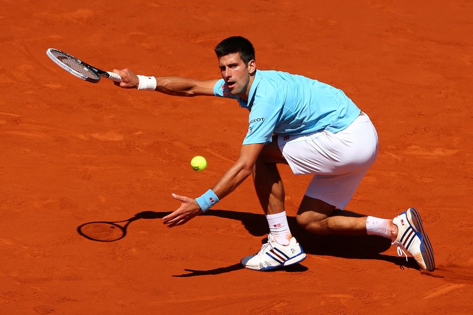 Novak Djokovic stoops to conquer during his French Open semifinal match against Ernests Gulbis of Latvia.