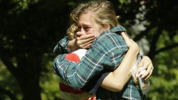 Two women embrace near a prayer circle on the campus of Seattle Pacific University, Friday, June 6, 2014 in Seattle. Classes were canceled Friday following a shooting at Otto Miller Hall Thursday afternoon. A 19-year-old man was fatally shot and two other young people were wounded after a gunman entered the foyer  and started shooting.  Aaron R. Ybarra, 26, was booked into the King County Jail late Thursday for investigation of homicide, according to police and the jail roster. (AP Photo/Ted S. Warren)