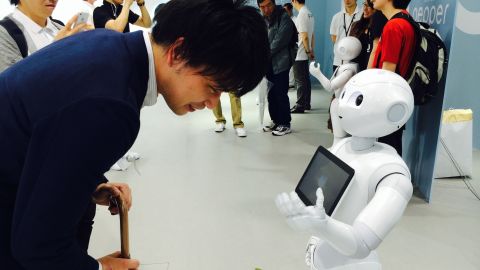 A customer leans over to hear Pepper's chirpy, childlike voice.