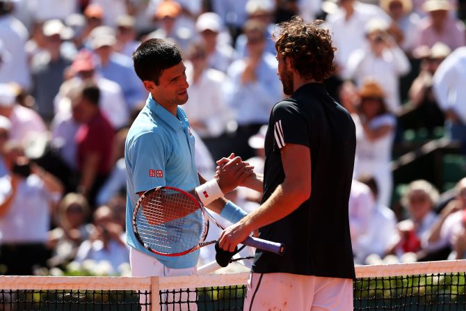 Djokovic and Gulbis embrace at the end of the match at a sun kissed Roland Garros. Djokovic will now aim to become only the eighth man to complete a career grand slam in Sunday's final.