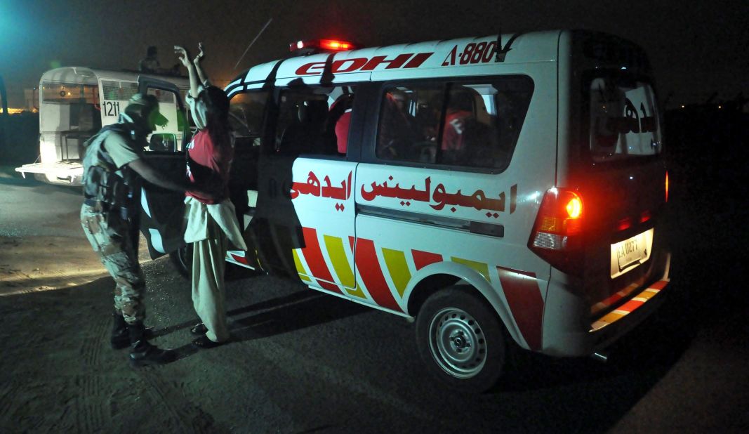 Pakistani rangers check ambulance staff at a boundary wall at the airport on June 8.