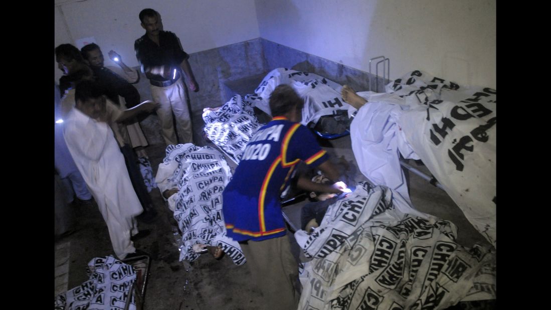 Police examine bodies of security personnel at a Karachi hospital on June 9.
