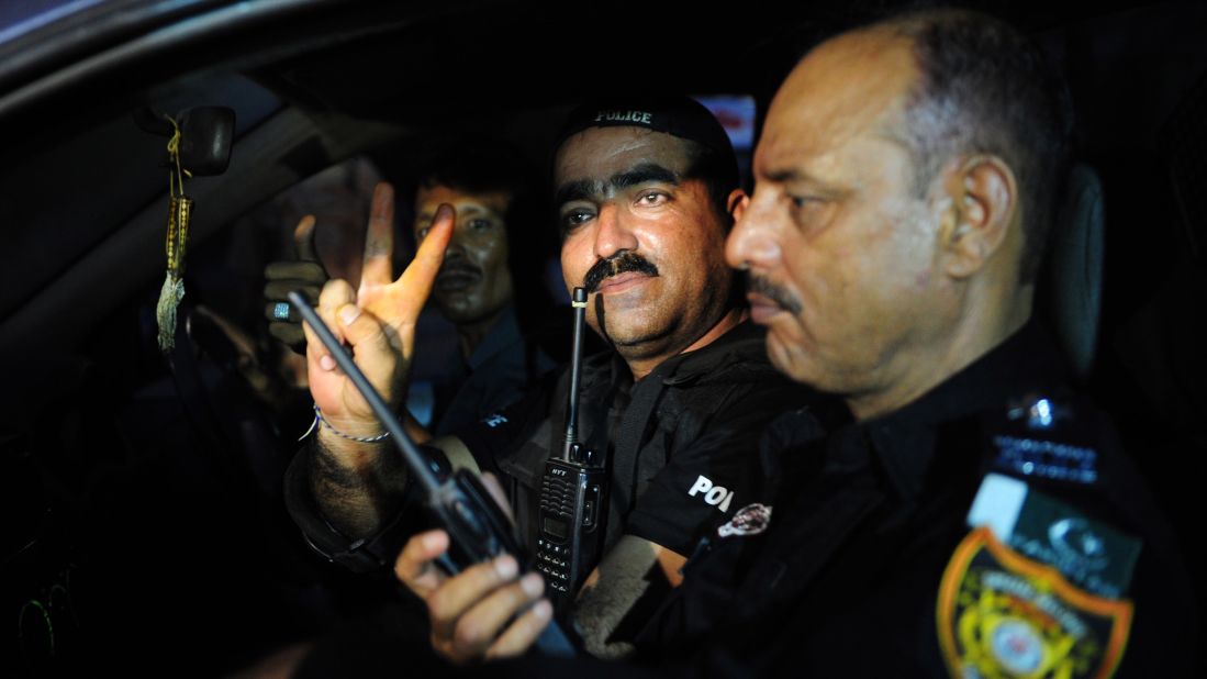 A police commando gives a victory sign June 9 after returning from an operation against militants at the Karachi airport.