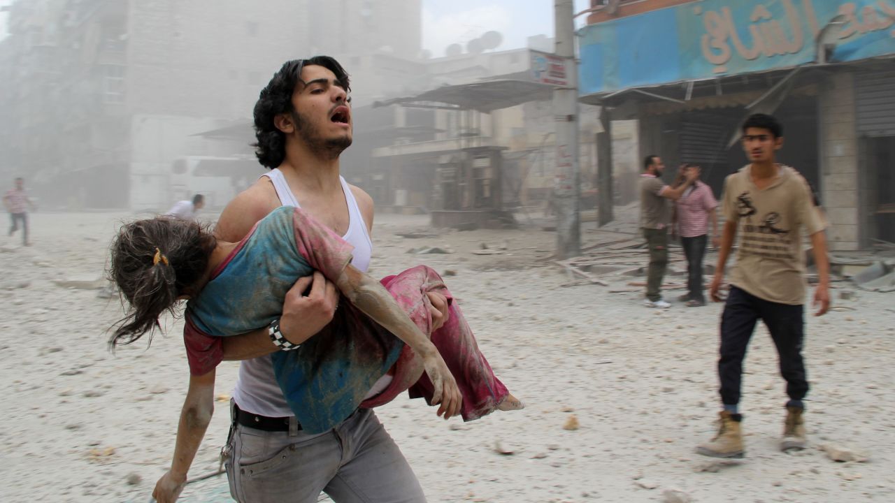 A man carries a girl injured in a reported barrel-bomb attack by government forces June 3 in Aleppo.