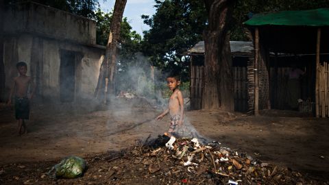 A boy pokes a trash fire in the Jan Mai Kawng IDP camp in Kachin State, Myanmar. About 600 people live in the camp.