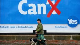 Colin MacDonald Provan walks his dog Colleen down Glasgow High Street past a Yes referendum campaign billboard On May 20, 2014 in Glasgow, Scotland.