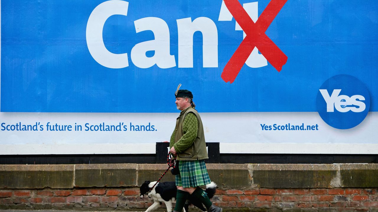 Colin MacDonald Provan walks his dog Colleen down Glasgow High Street past a Yes referendum campaign billboard On May 20, 2014 in Glasgow, Scotland.