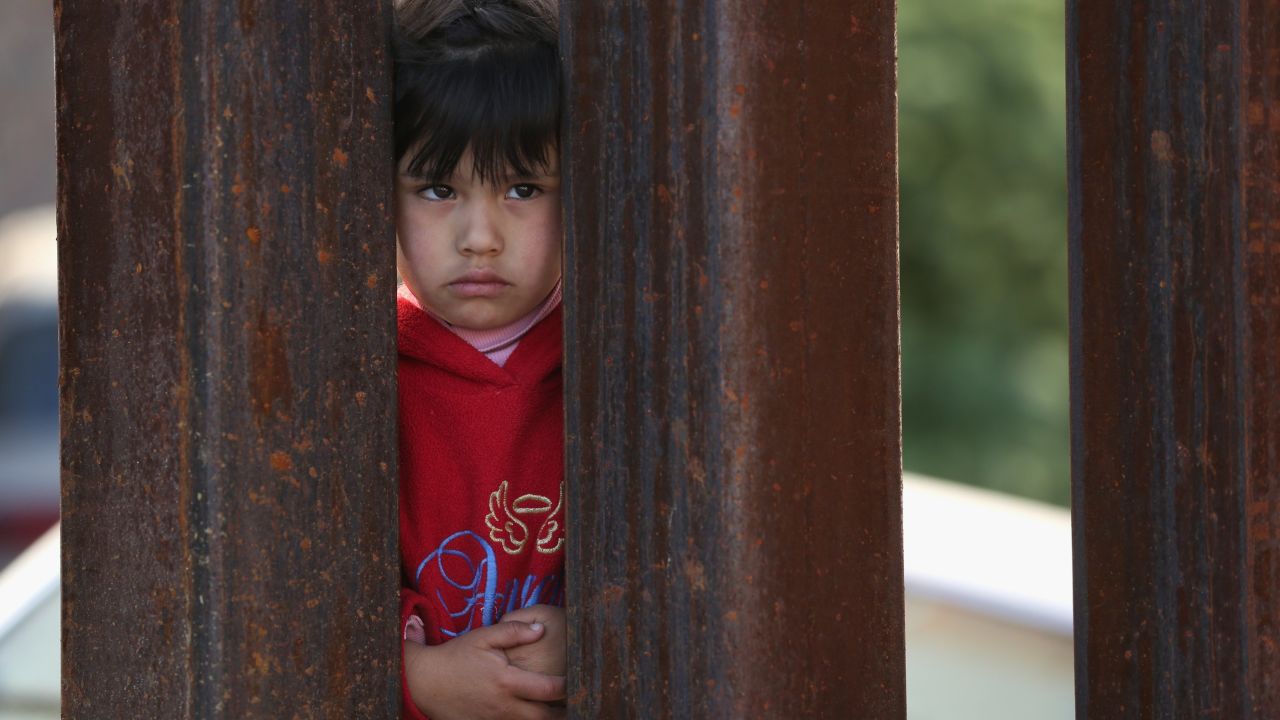 A child on the Mexican side of the U.S.-Mexico border fence looks into Arizona during a special 'Mass on the Border' on April 1, 2014 in Nogales, Arizona.