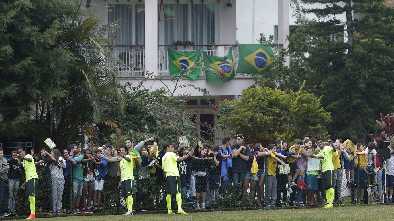 Members of the Brazilian national soccer team take selfies and sign autographs for fans after a training session Monday, June 9, in Teresopolis, Brazil.