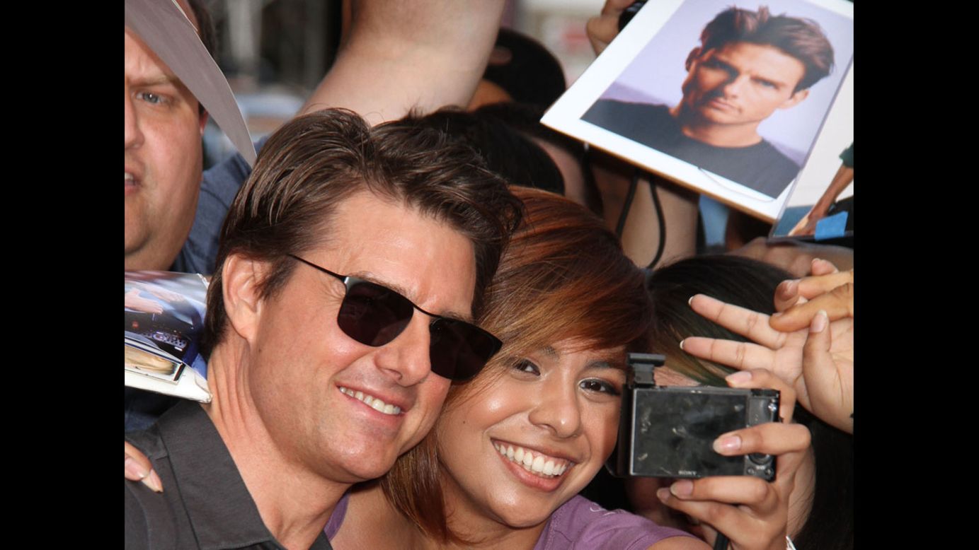 Actor Tom Cruise takes a photo with a fan in New York on Thursday, June 5. He was there to appear on "The Daily Show with Jon Stewart."