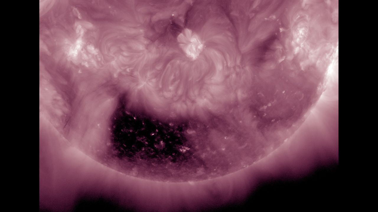 A coronal hole, almost square in its shape, is one of the most noticeable features on the sun on May 5-7, 2014.  A coronal hole is an area where high-speed solar wind streams into space. It appears dark in extreme ultraviolet light as there is less material to emit in these wavelengths. Inside the coronal hole, you can see bright loops where the hot plasma outlines little pieces of the solar magnetic field sticking above the surface. Because it is positioned so far south on the sun, there is less chance that the solar wind stream will impact us here on Earth. 