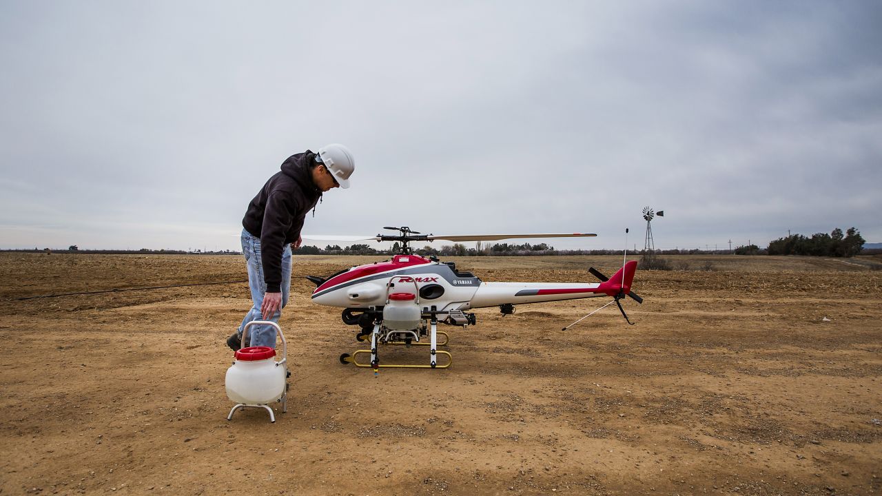 A researcher at the University of California, Davis, removes sprayer containers from a drone after a crop dusting test flight in Arbuckle, California, on February 5, 2014. UC Davis is testing the use of unmanned helicopters for agriculture. The FAA does not currently allow pesticide spraying from drones in the United States.