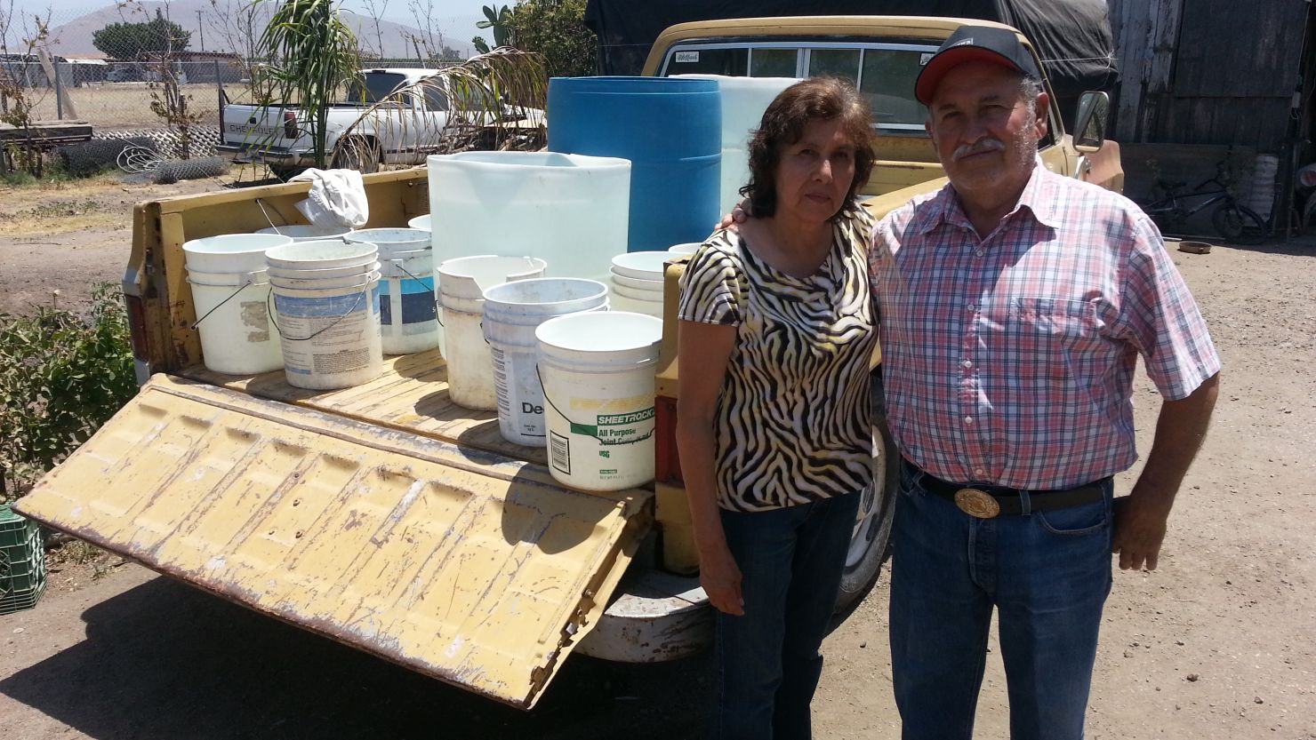 Simona and Adolfo Magaña have no running water; they fill these buckets from a neighbor's tap.