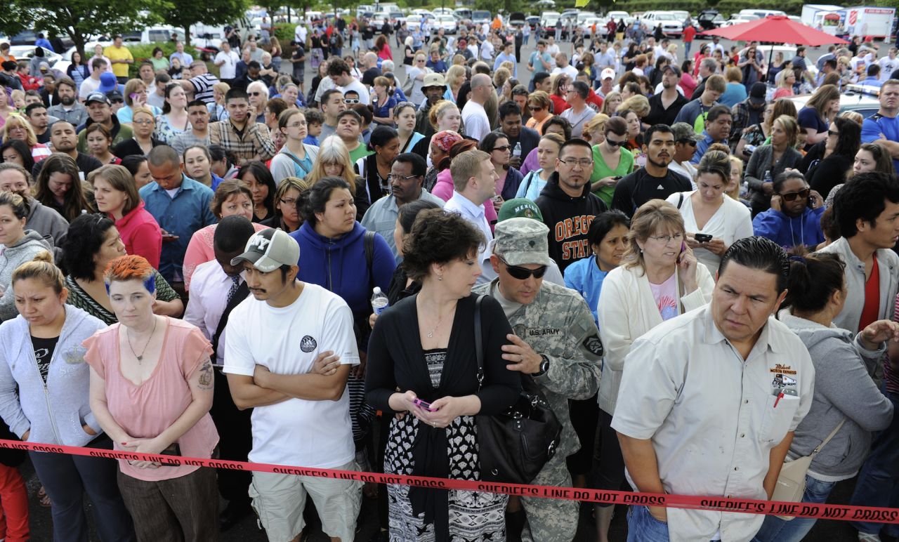 Parents anxiously wait for their children at the shopping center parking lot in Wood Village on June 10.