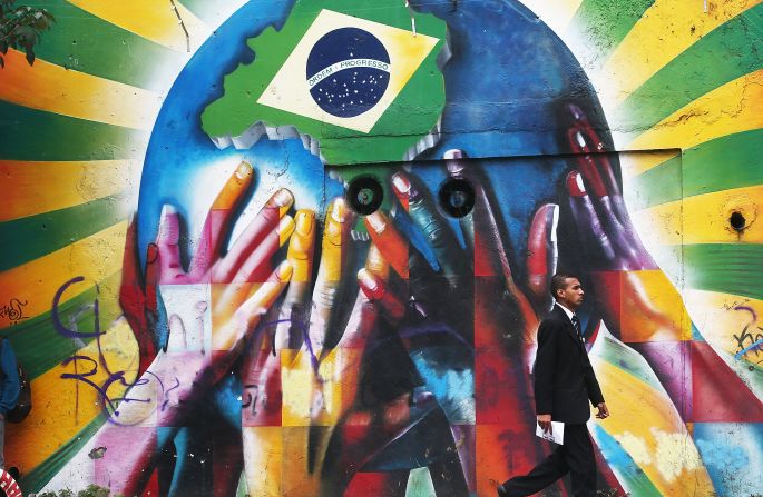 In this attention-grabbing image a collection of multi-colored hands support the planet marked with a Brazilian flag, welcoming visitors from across the world to South America's largest nation.