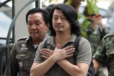 Thai anti-coup activist Sombat Boonngamanong, center, gestures as he arrives escorted by police and soldiers at a military court in Bangkok on Thursday, June 12. The prominent anti-coup figure faces up to 14 years in prison if convicted of incitement, computer crimes and ignoring a summons by the junta, police said. The Thai military carried out a coup May 22 after months of unrest had destabilized the country's elected government and caused outbursts of deadly violence in Bangkok.