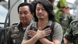 Thai anti-coup activist Sombat Boonngamanong (C) gestures as he arrives escorted by police and soldiers at a military court in Bangkok on June 12, 2014. The prominent anti-coup activist faces up to 14 years in prison if convicted of incitement, computer crimes and ignoring a summons by the junta, police said on June 12.    AFP PHOTO / Christophe ARCHAMBAULT        (Photo credit should read CHRISTOPHE ARCHAMBAULT/AFP/Getty Images)