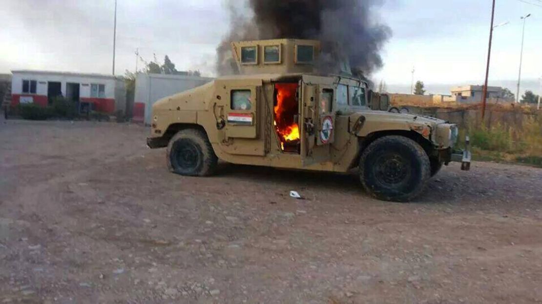A picture taken with a mobile phone shows an armored vehicle belonging to Iraqi security forces in flames.