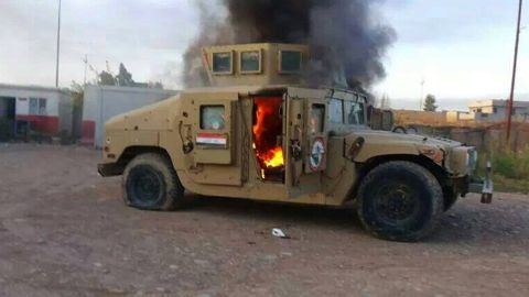A picture taken with a mobile phone shows an armored vehicle belonging to Iraqi security forces in flames.