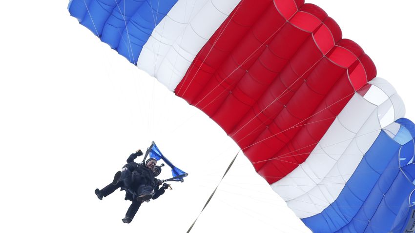 Former President George H.W. Bush, strapped to Sgt. 1st Class Mike Elliott, a retired member of the Army's Golden Knights parachute team, float to the ground during a tandem parachute jump near Bush's summer home in Kennebunkport, Maine, Thursday, June 12, 2014. Bush made the jump, his eighth, in celebration of his 90th birthday. (AP Photo/Robert F. Bukaty)