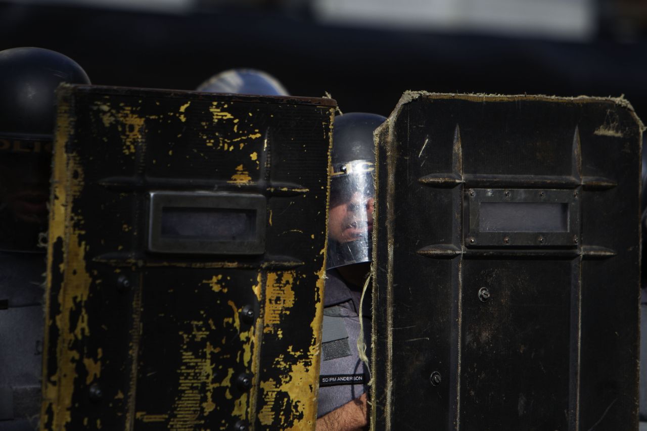 Brazilian police stand behind shields during clashes with protesters.