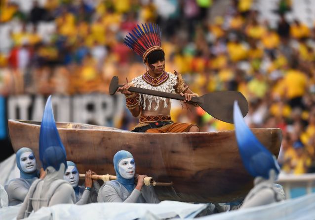 Un artista disfrazado de "indio" es transportado en una canoa durante la ceremonia de apertura.
