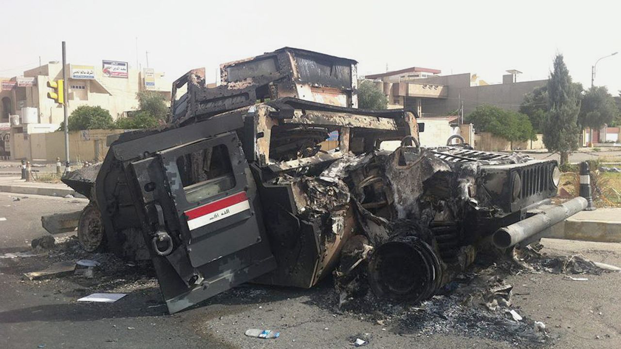 Iraqi army armored vehicle is seen burned on a street of the northern city of Mosul, Iraq, Thursday, June 12, 2014.