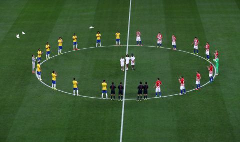 Brazil and Croatia players stand around the center circle as doves are released before the beginning of the match.