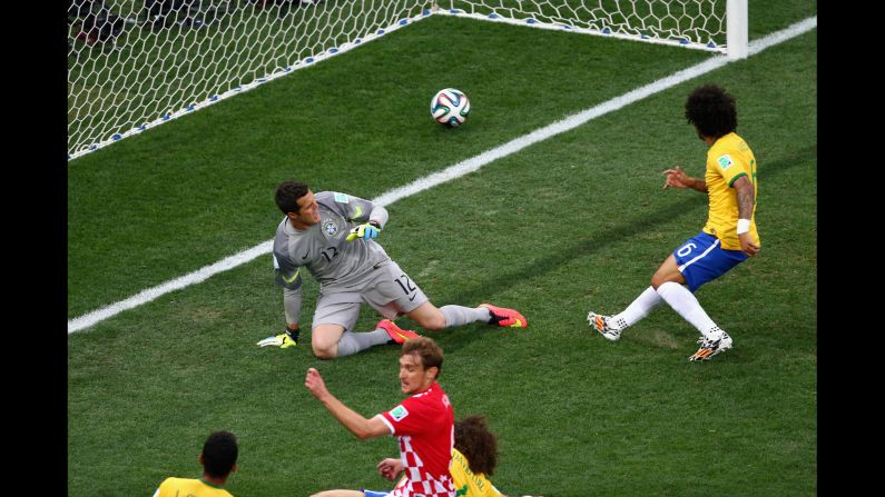 Marcelo, right, accidentally deflects the ball past his own goalkeeper, Julio Cesar. It was the <a href="index.php?page=&url=http%3A%2F%2Fwww.cnn.com%2F2014%2F06%2F12%2Ffootball%2Fgallery%2Fworld-cup-goals%2Findex.html">first goal of the match</a> and put the hosts in an early hole. <a href="index.php?page=&url=http%3A%2F%2Fwww.cnn.com%2F2014%2F06%2F12%2Ffootball%2Fgallery%2Fworld-cup-goals%2Findex.html">See all the goals from the World Cup</a>