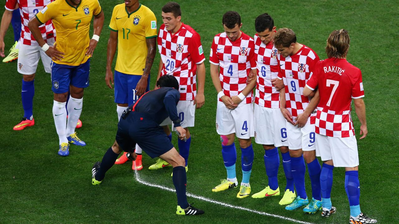 A referee sprays a temporary line on the field during Thursday's opening World Cup match between Brazil and Croatia.