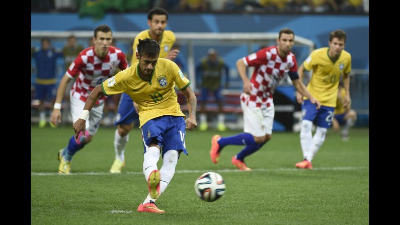 Brazil forward Neymar strikes the ball to <a href="index.php?page=&url=http%3A%2F%2Fwww.cnn.com%2F2014%2F06%2F12%2Ffootball%2Fgallery%2Fworld-cup-goals%2Findex.html">score a penalty</a> and give his team a 2-1 lead in the second half against Croatia.