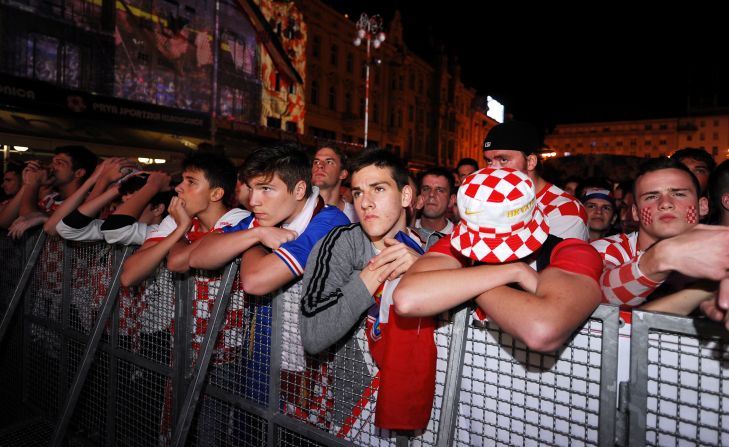 Aficionados croatas se muestran desconsolados mientras ven el partido inaugural en Zagreb, Croacia.