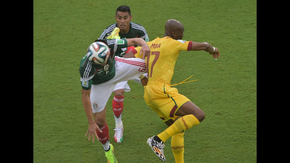 Mbia challenges Mexico midfielders Herrera, left, and Vazquez.