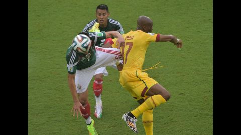 Mbia challenges Mexico midfielders Herrera, left, and Vazquez.