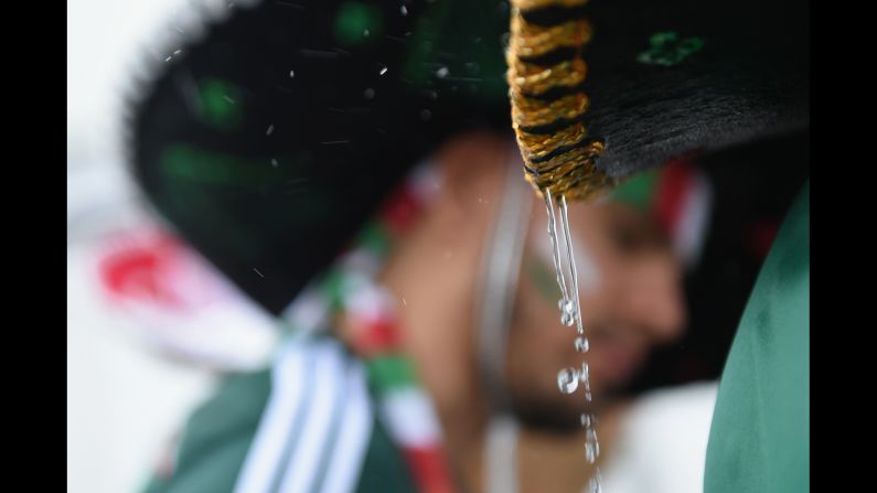 Rain drips off a Mexico fan's sombrero before the match. <a href="index.php?page=&url=http%3A%2F%2Fwww.cnn.com%2F2014%2F06%2F12%2Ffootball%2Fgallery%2Fworld-cup-0612%2Findex.html">See the best World Cup photos from June 12.</a>