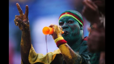 A Cameroon fan blows a horn during the match. 