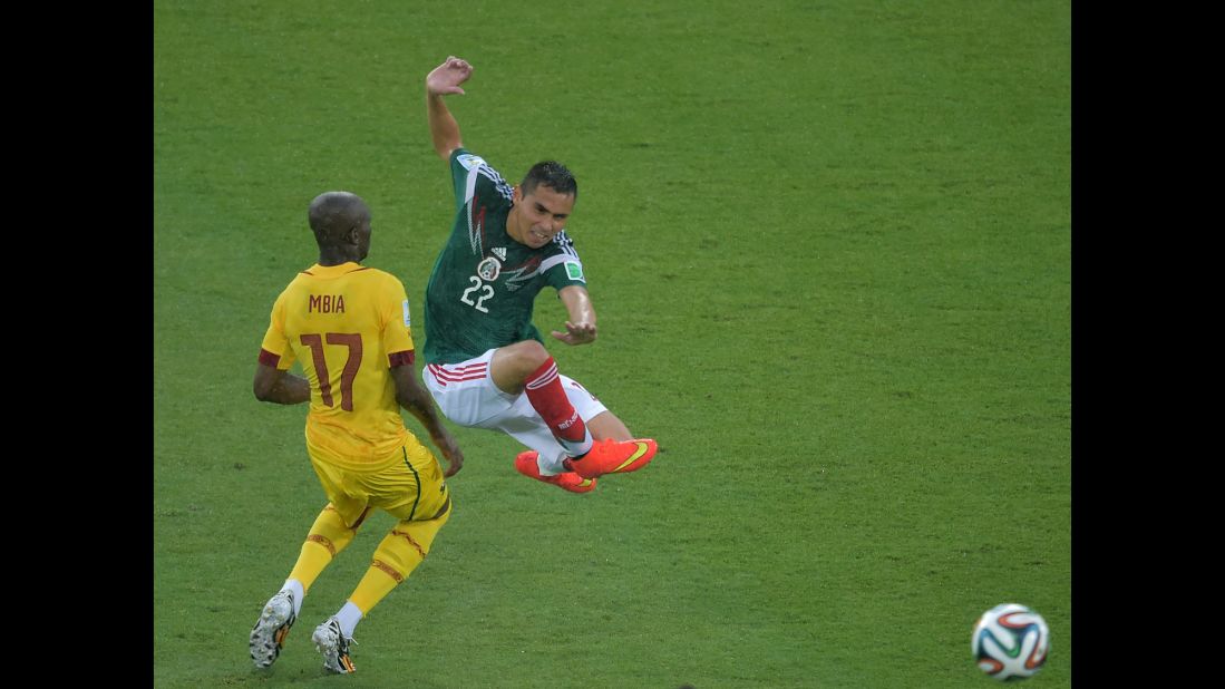 Mexico's Paul Aguilar jumps near Mbia.