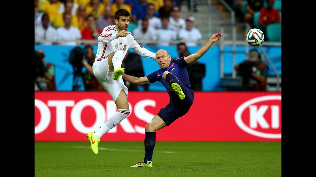 Spanish defender Gerard Pique, left, chases down Robben.