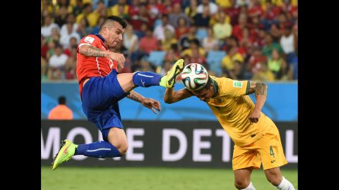 Australian forward Tim Cahill, right, and Chilean defender Gary Medel vie for the ball.